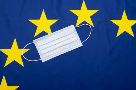 Surgical mask, medical mask on fabric EU or European Union flag, concept picture