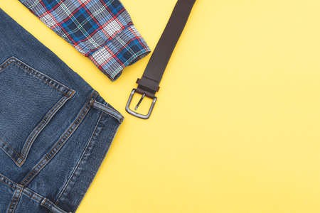 Fashion background, jeans, shirt, belt. Denim style. Top view. Men clothes on yellow background, space for text.の写真素材