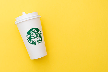 BERLIN - NOV 8: Starbucks Paper Cup. Starbucks Coffee with Logo Mermaid isolated on yellow background in Berlin on November 8. 2020 in Germanyのeditorial素材
