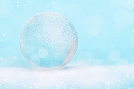 Snowglobe or glass ball covered by snow with glitter, Christmas decoration, layout, space for text, postcard.の写真素材