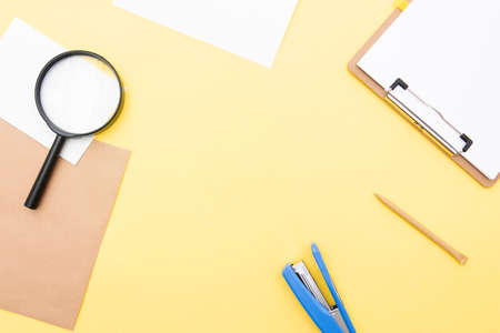 Business composition, layout with blank paper, pen, magnifier on yellow background, top view, space...
