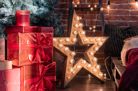 Christmas or New Year interior of living room, apartment with Christmas tree, gift boxes, gloving star, garlandsの写真素材