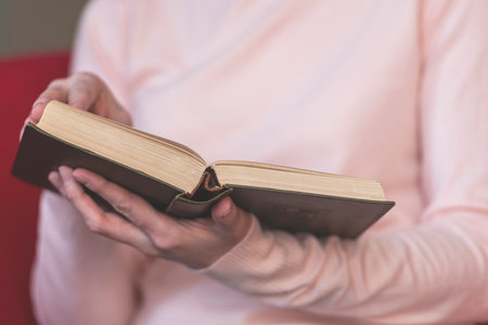 Girl holding book, reading old book. Toned picture
