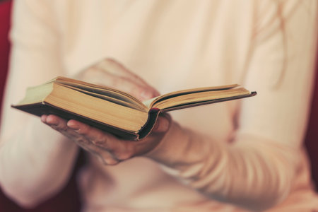 Girl reading book, woman holding open book, toned pictureの写真素材