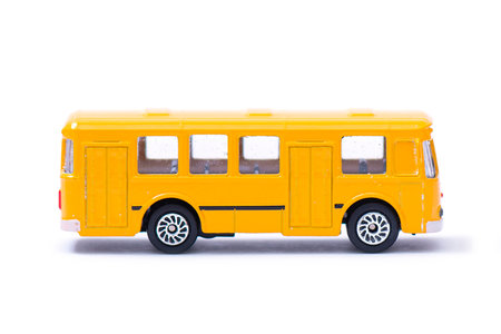 Plastic model of an old yellow bus, toy, miniature isolated on white