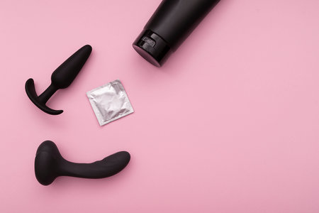 Black rubber sex toys, silicone sex toy and lubricant on pink background, sex composition, layoutの写真素材