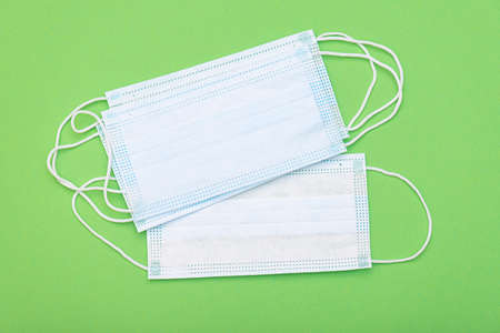 Protective medical masks on green background, top view, medical theme