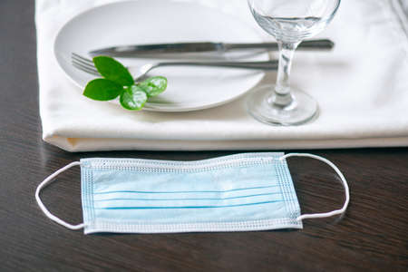 Protective medical mask on the table at cafe or restaurant, concept picture about social distancing during pandemic in the Worldの写真素材