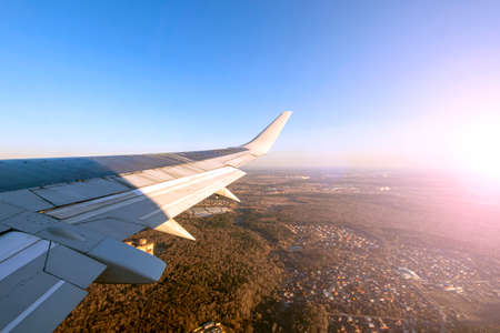 Airplane going for landing. View from airplane window on the wing during sunsetの写真素材
