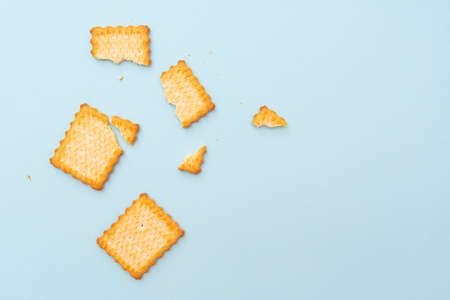 Broken dry cookies on blue background, top view, lay outの写真素材