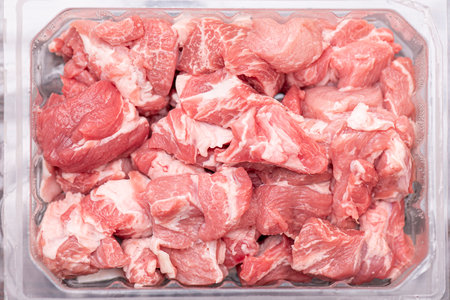 Close-up pieces of raw pork in plastic container. Slices of fresh meat, pork from the shop, market,...