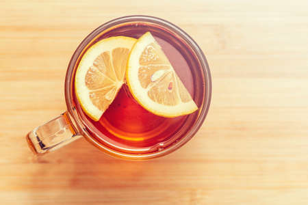 Black Tea with slices of Lemon in glass mug, top view