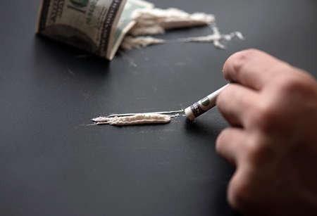 White powder as drug with money on black surface, concept pictureの写真素材