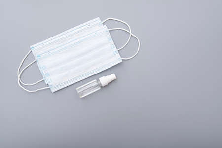 Surgical mask, medical mask and alcohol antibacterial antiseptic hand gel on gray background, concept pictureの写真素材