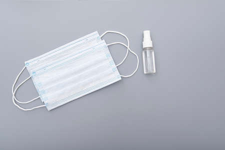 Surgical mask, medical mask and alcohol antibacterial antiseptic hand gel on gray background, concept pictureの写真素材