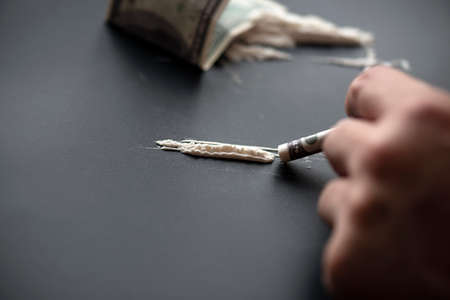 White powder as drug with money on black surface, concept picture