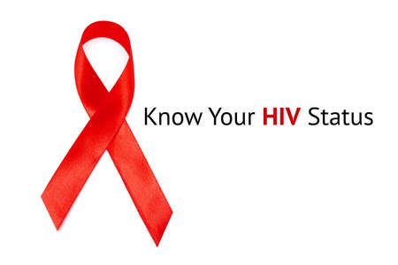 KNOW YOUR HIV STATUS inscription on white Background and red Ribbon as symbol of HIV and AIDSの写真素材