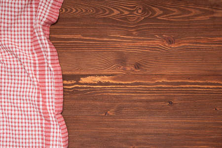 Checkered tablecloth or cloth napkin on wooden table with space for text, ideas. Top viewの写真素材