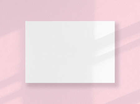 Blank square card, white sheet as mockup with sunny shadows on pink surfaceの写真素材