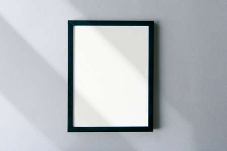 Blank photo frame mockup with shadows and sunlight on surface. Template with space for text.の写真素材