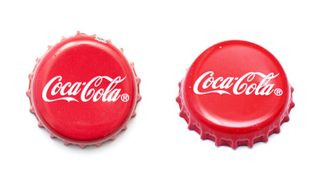 BERLIN - JUNE 23: Used, damaged classic Coca Cola cap isolated on white. Top and side views of cola caps in Berlin, June 23, 2021 in Germanyのeditorial素材