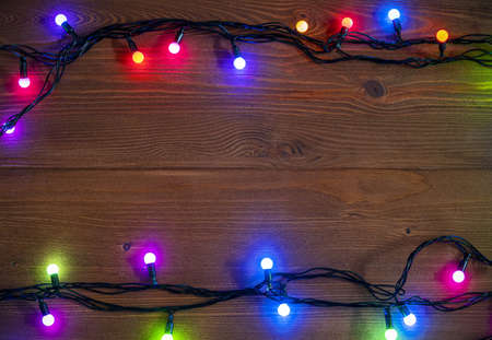 Christmas background with glowing garlands on wooden surface, light of Christmas garland, space for text, top viewの写真素材