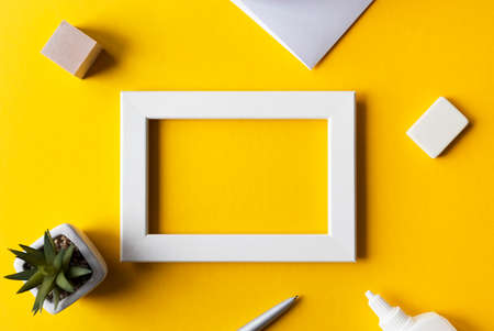 Creative workplace or workspace with bright yellow surface, blank photo frame, office accessories, top view, space for text.の写真素材