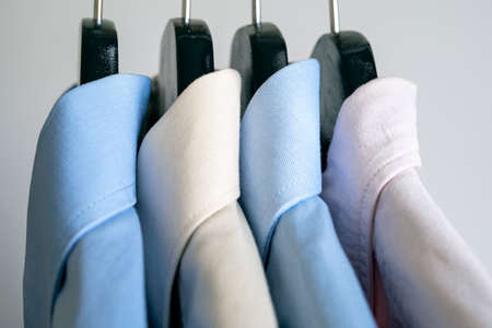 Close-up of hangers with business shirts. Row of colored shirts on a rack. Cloth hanger with casual...