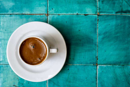 Traditional Turkish Anatolian coffee in white ceramic cup on vintage table at an old Turkish cafeの写真素材