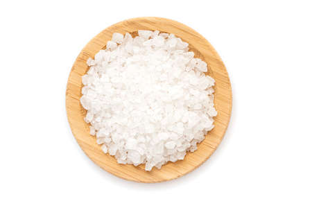Wooden plate with grains of sea salt isolated on white, top viewの写真素材