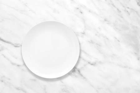 White plate on marble stone table, plate mockup, top viewの写真素材
