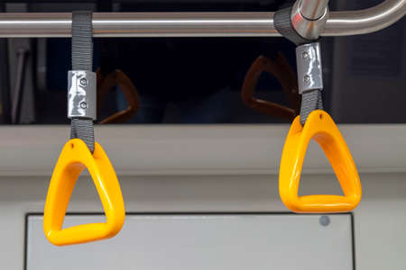 Close-up of an empty yellow handrail or handles for passenger in metro. Concept about social distanceの写真素材