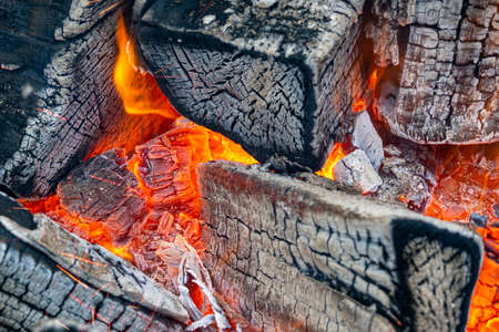 Close-up of flame, fire with ash, logs, wood. Selective focusの写真素材