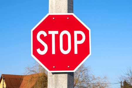 STOP red road sign on a pillar in a street