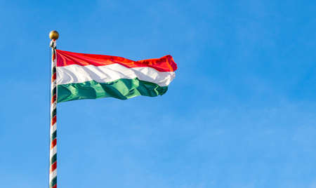 Hungarian flag or flag of Hungary waving against blue sky, space for textの写真素材