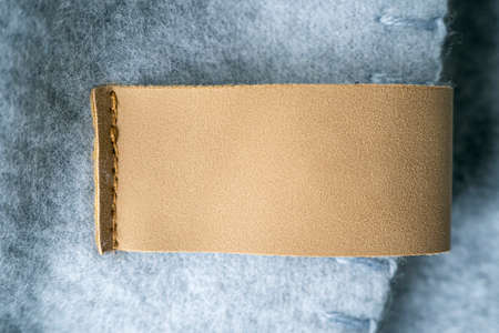 Leather blank label, brown patch on a blanket as mockup, space for textの写真素材