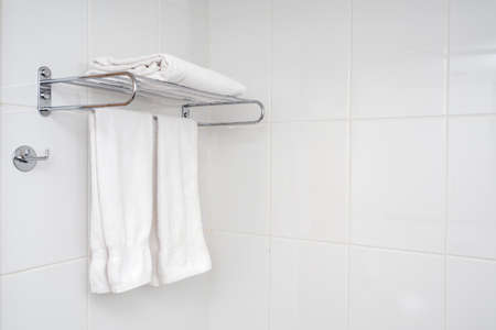 Interior of bathroom with iron shelf and soft towels. White tiles with minimal composition in bathroom.の写真素材