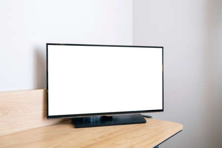 Blank white screen of LED TV as mockup on a desk, space for textの写真素材