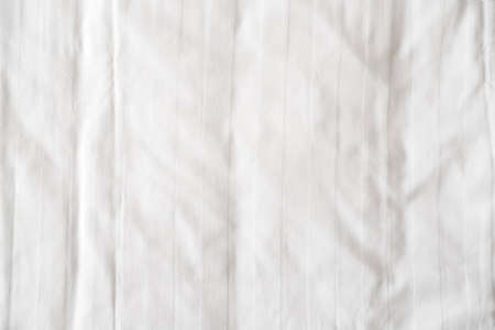 White bed linen, sheet as texture or background, crumpled blank bedclothes top viewの写真素材