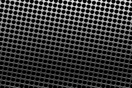 Large silver iron metal plate with mesh or round holes as texture or backgroundの写真素材