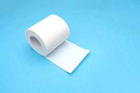 White blank roll of toilet paper with long sheet as mockup, on blue background, top view