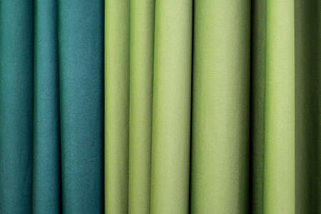 Folded vertical curtains lime and blue-green color curtains as hotel interiorの写真素材