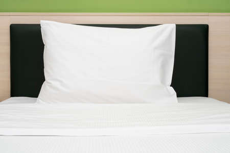 White clean pillow on a bed at a hotel room, front viewの写真素材