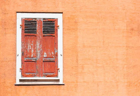 Red wooden vintage shutters and stone wall, traditional European architectureの写真素材