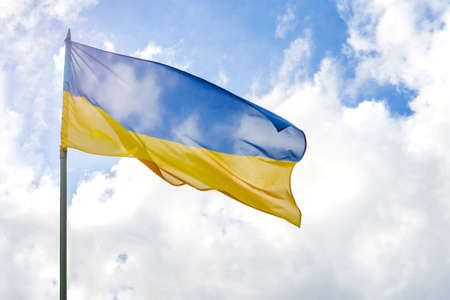 Flag of Ukraine in front of cloudy and sunny blue skyの写真素材