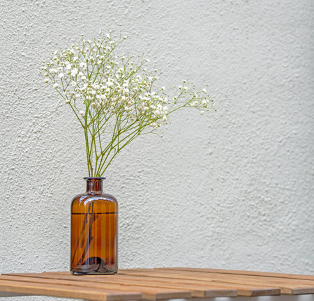 Still Life with minimal floral composition on wooden table at a street cafeの写真素材