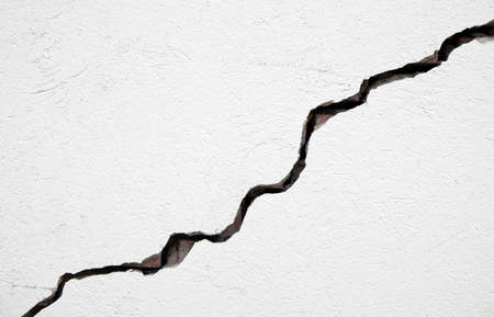 Long deep crack on the damaged wall as texture or backgroundの写真素材