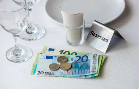 European union currency on a table with receipt bill, wine glasses, plate in restaurant in Europeの写真素材