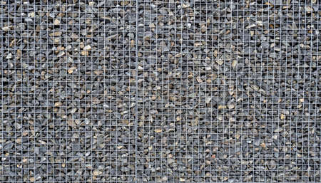Gabion with heaps of small stones in a grid as the city or garden decoration, textured backgroundの写真素材