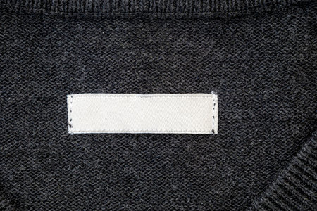 Blank stripe, label for branding on sweater. Tag mockup on gray cloth, top view.の写真素材